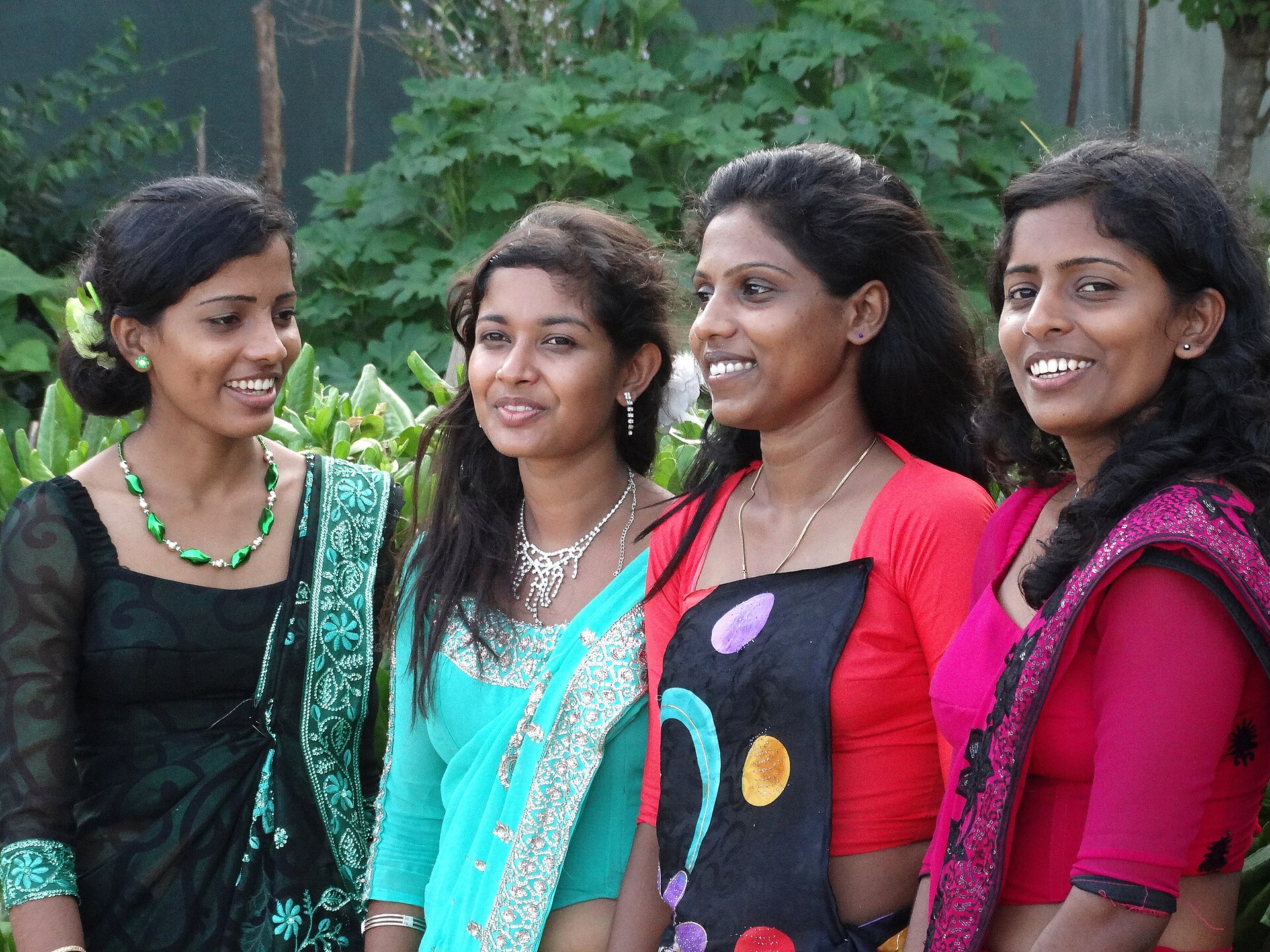 Bridesmaids in bright saris at a beach wedding on Medaketiya Beach, Tangalle, Sri Lanka.